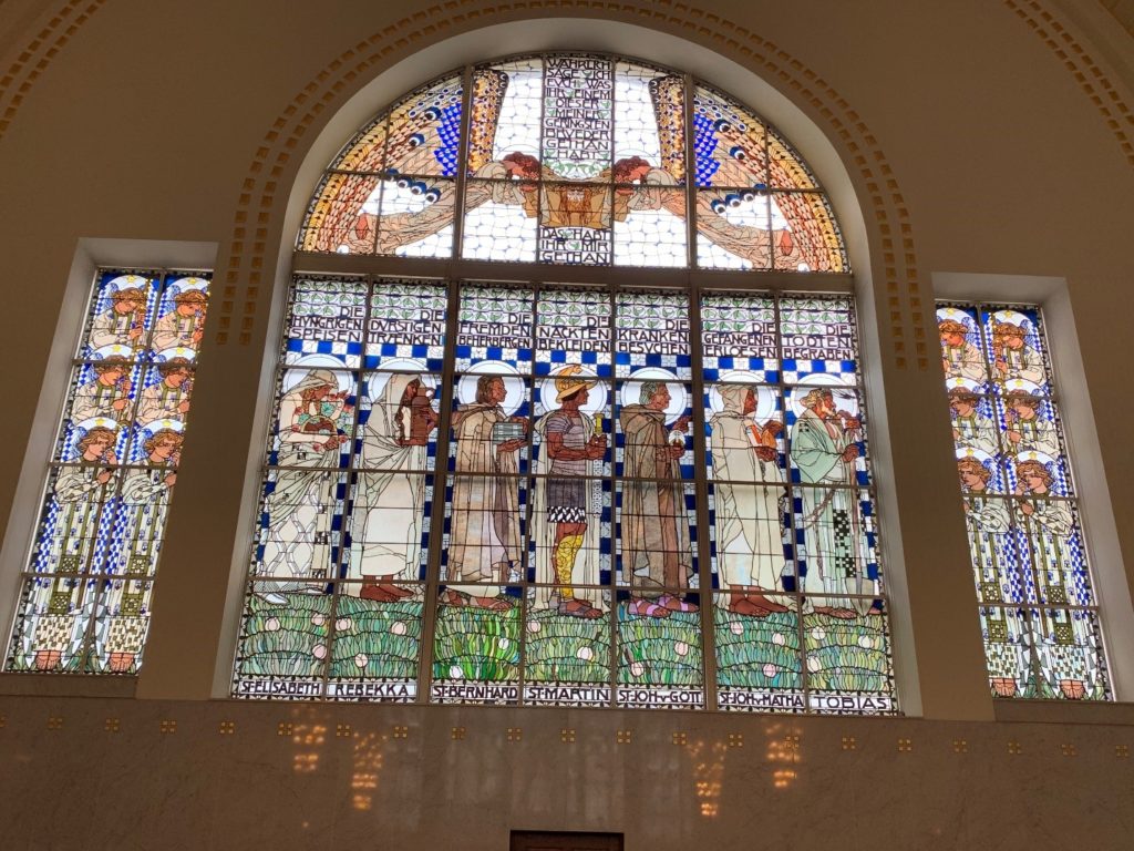 Window at St. Leopold’s Church, depicting the seven corporal works of mercy. Photograph by Margaret S. Chisolm