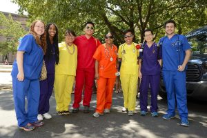 A group of healthcare providers in rainbow-colored scrubs.