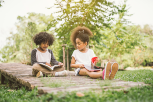 2 kids reading outside