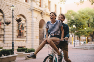 couple riding bikes with no helmets