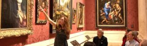 Teacher and students looking at artwork in a museum
