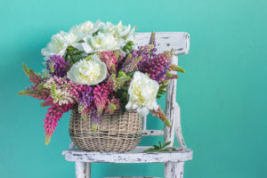 Basket with flowers peonies and lupines