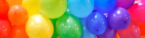 Wide celebration banner background with rainbow multicolored balloons.