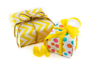 Packaged gift in colored and yellow paper on white background