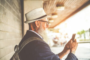 Trendy senior man using smartphone app