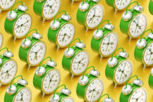 Arranged to rows vintage alarm clocks which are standing one after another on yellow reflective surface. 3D rendering graphics.
