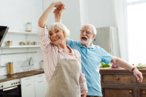smiling senior couple dancing in kitchen