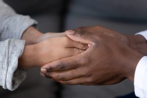 doctor holding patients hands in empathy and support