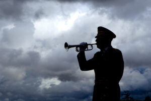 Silhouette of a man playing taps on his bugle at a veterans funeral at Medical Lake Veterans Memorial in Washington.