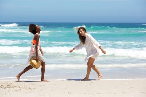 2 women walking on the beach