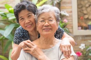 Asian female older ageing women smiling with happiness in garden at home, nursing home, or wellbeing county