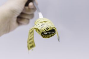 Tape measure simulating ready-to-eat food with cutlery Conceptual of diet, low calorie food