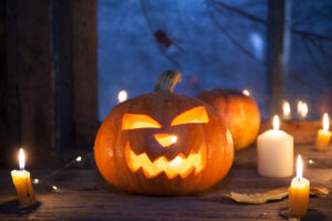 Halloween background, Jack-o ' - lantern pumpkins next to burning candles on night window background
