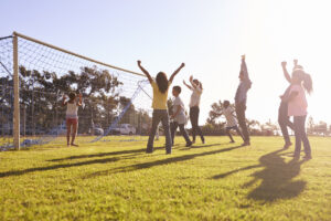 Diverse Families cheering scoring a goal during a football game