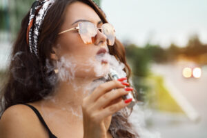Closeup portrait gorgeous young girl smoking e-cigarette