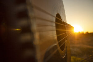 Image was taken during the golden hour,just an hour before the sundown,of an acoustic guitar wich its chords leads people's eye straight to the sunset.