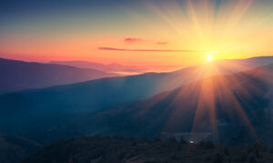 Panoramic view of colorful sunrise in mountains. Filtered image:cross processed vintage effect.