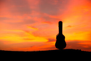 Silhouette of guitar case at sunset