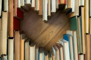 Love concept of heart shape from old vintage books on wooden floor background. Vintage colour tone style composition of love with open book heart shape