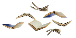 A flock of flying paper books isolated on a white background. Open books in the air. Textbooks, library.
