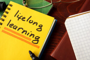 Notebook with lifelong learning sign on a table. Education concept.
