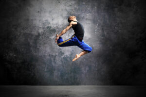 Young dancer is jumping on stage