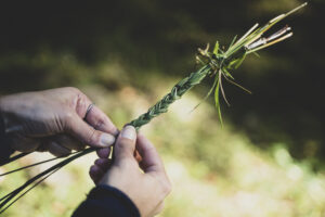 woman braiding grass
