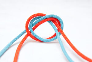 Heart shape made of two intertwined cords isolated on a neutral background.