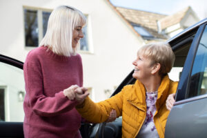 Female Neighbor Giving Senior Woman A Lift In Car