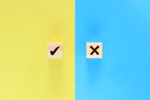 The building blocks labeled check mark and "x" are placed on a yellow and blue background, respectively.