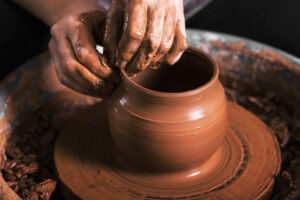 hands of a potter, creating an earthen jar on the circle
