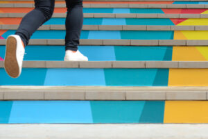 Lower part of teenage girl in casual shoe walking up outdoor colorful stair,teenage lifestyle successful concept