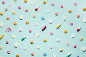 A photo of different medicinal drugs, tablets and pills on blue background.