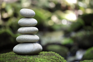 Stack of pebble stones by a stream in a forest