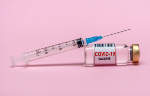 Vaccine ampoule, antibiotic. Medicine. Vial with a vaccine against the virus. Pink background.