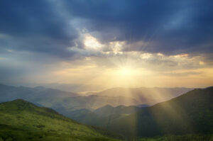 Carpathian mountains summer sunrise landscape with alpine pines, rocks and sun shining