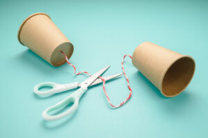 Old style cup phone with scissors to cut the string, a concept for two way communication lose, or cut contact, communication breakdown, problem, or error communicating