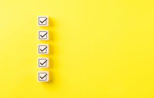 Checklist concept. Correct sign tick check mark on wooden block with copy space for the checklist on yellow background. Business survey questionnaire, Exam test process, filling digital form online,