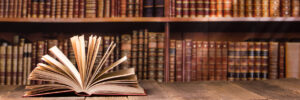 Vintage old hardback books, diary, fanned pages on wooden desk table and grunge background Daylight. Books stacking. Back to school. Copy Space. Education background