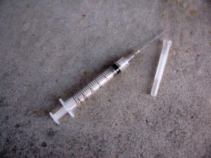 Syringe and needle on concrete floor