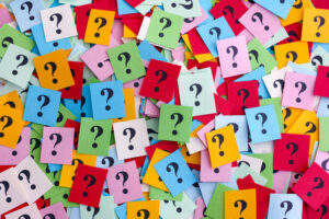 Too Many Questions. Pile of colorful paper notes with question marks. Closeup.